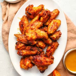 overhead view of mango habanero chicken wings on a white oval platter.