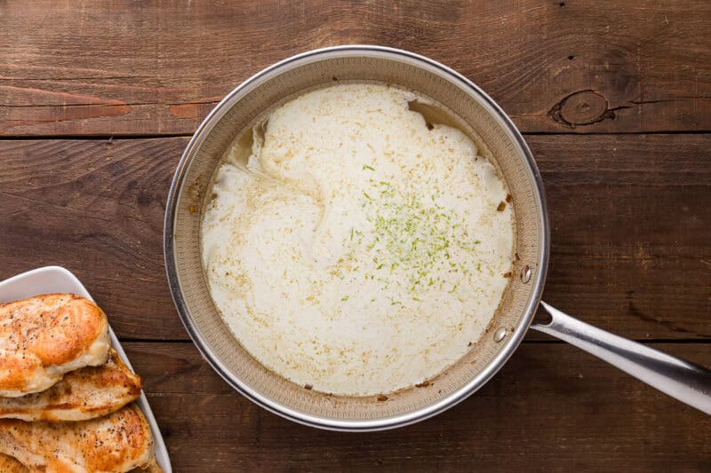 adding cream, lime juice, and lime zest to a skillet.