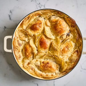 baked chicken thighs and potatoes dauphinoise in a braiser.