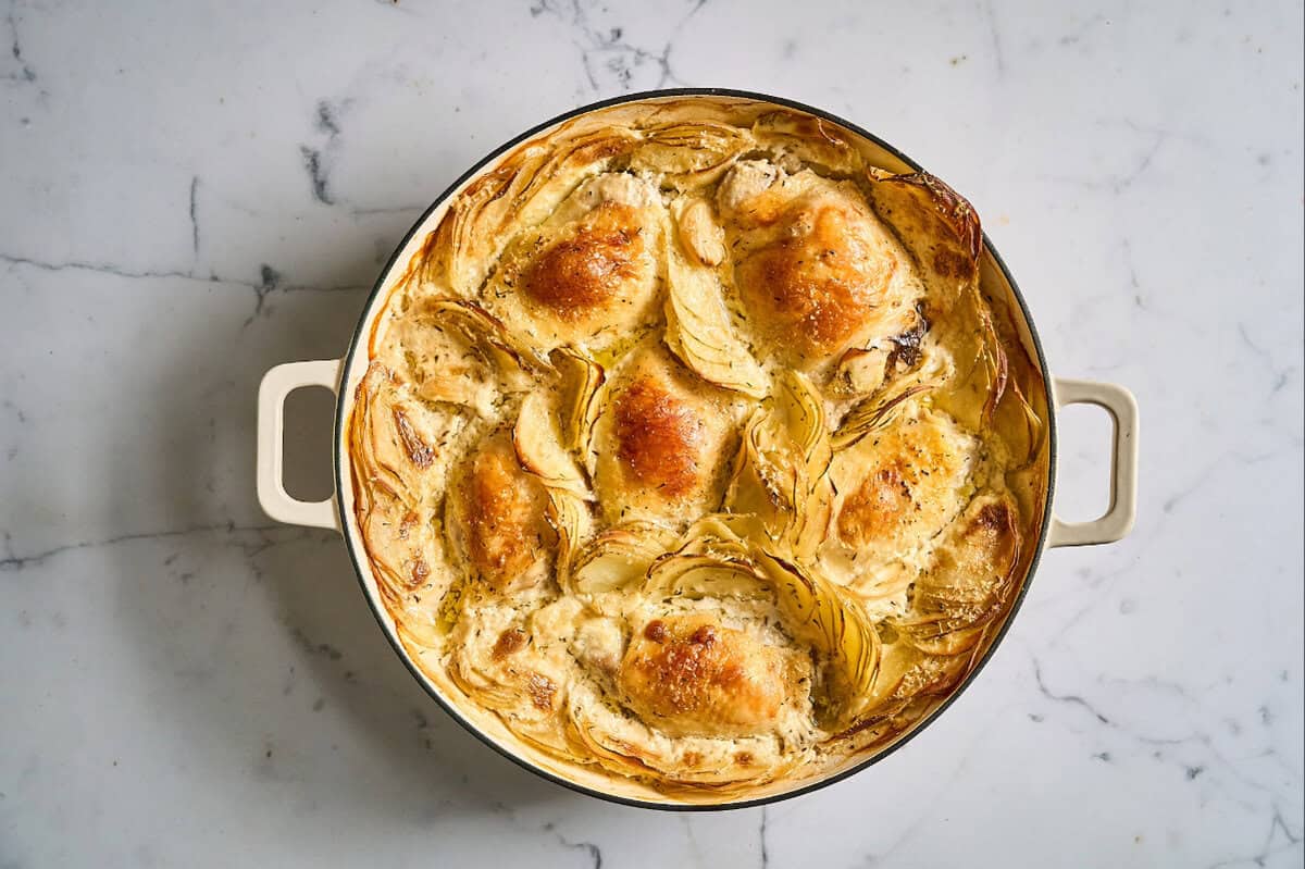 baked chicken thighs and potatoes dauphinoise in a braiser.