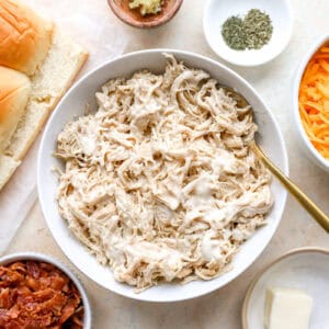 shredded chicken mixed with ranch dressing in a white bowl.