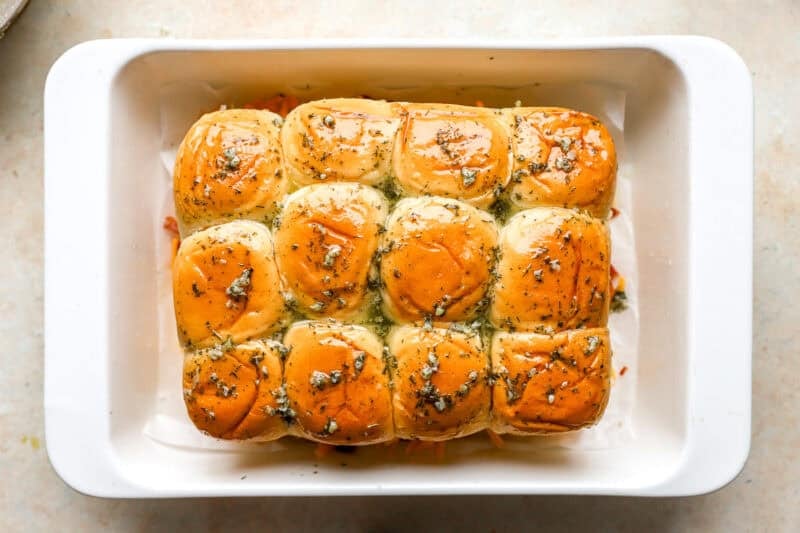 chicken bacon ranch sliders topped with seasoned melted butter before baking.