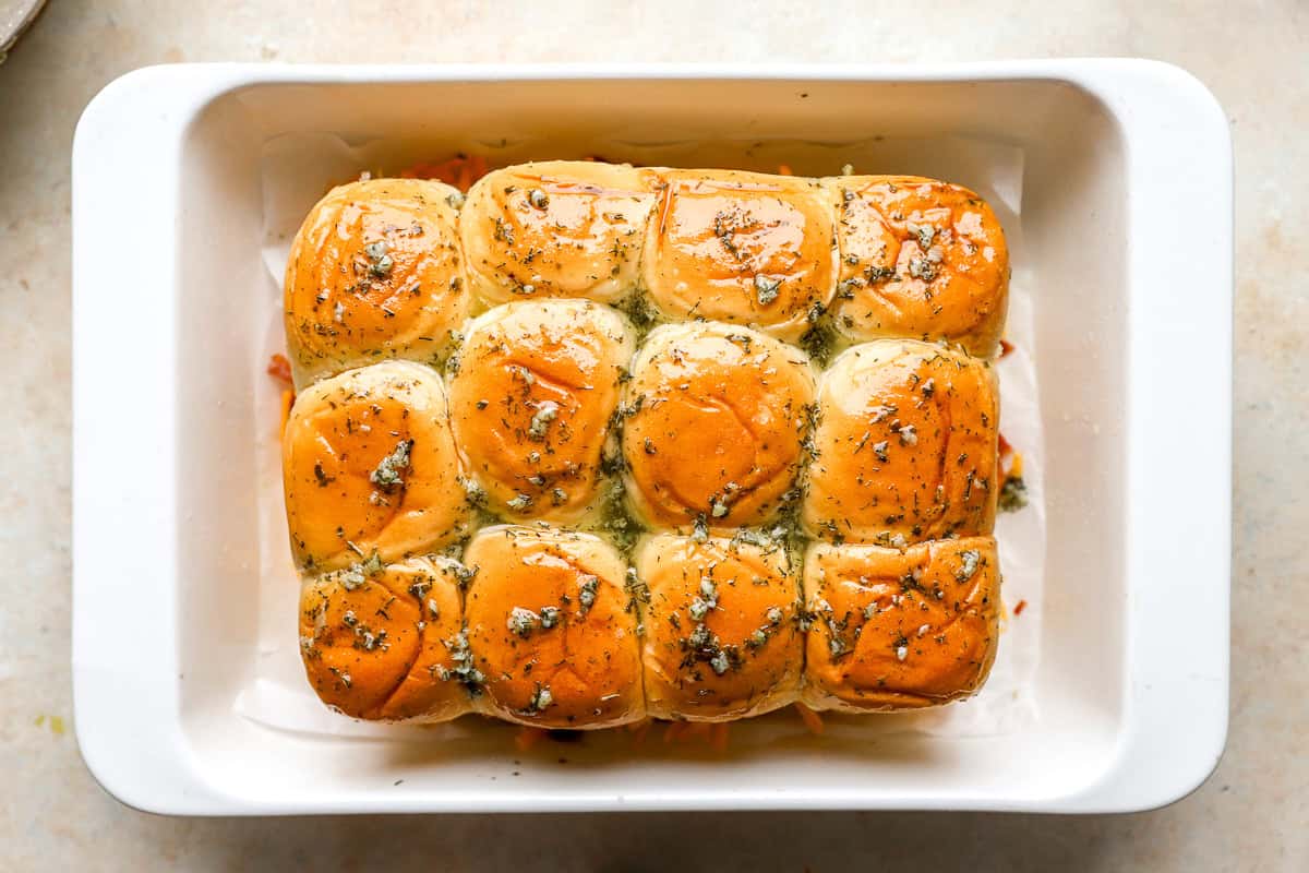 chicken bacon ranch sliders topped with seasoned melted butter before baking.