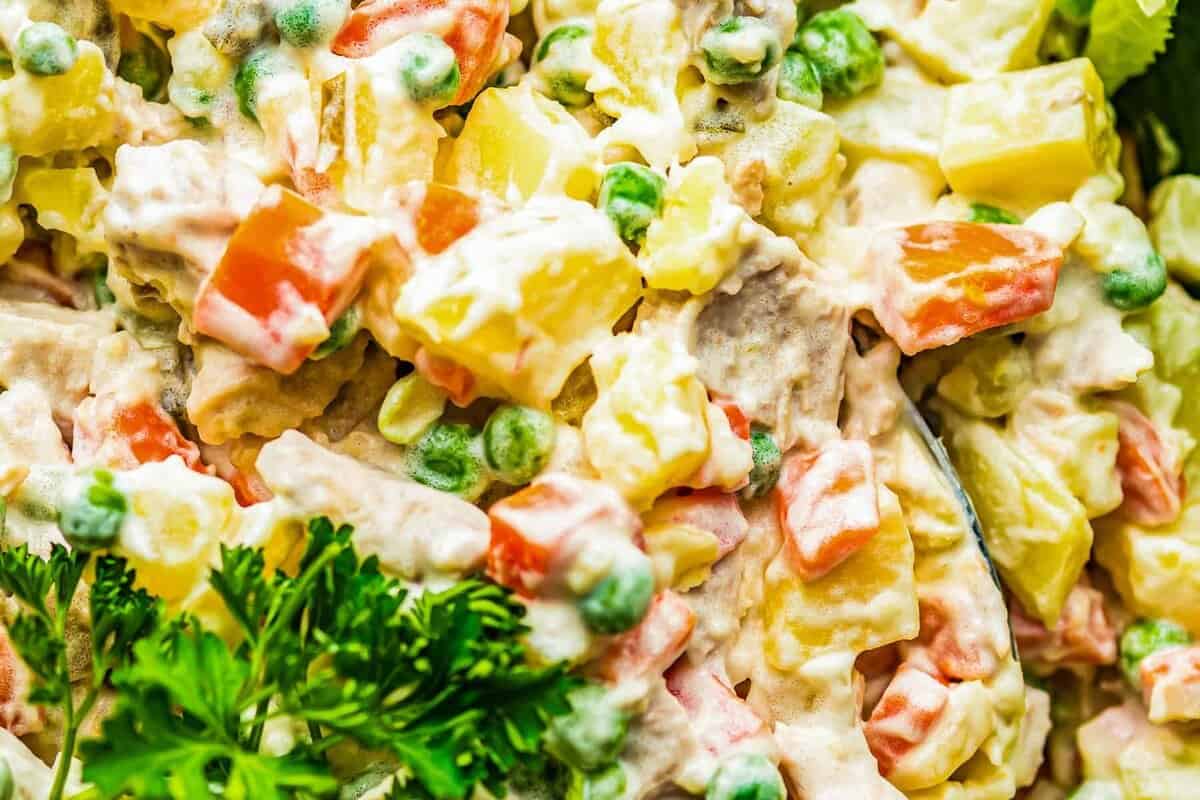 Creamy potato salad with chicken, carrots, and peas.