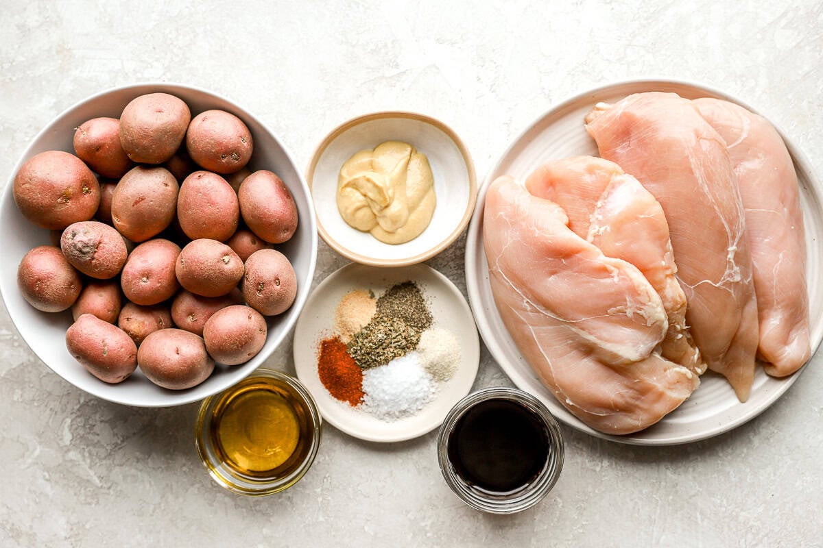 overhead view of portioned ingredients for crockpot chicken and potatoes in individual bowls.