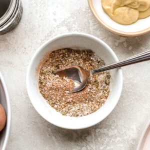 seasoning blend in a white bowl with a spoon.