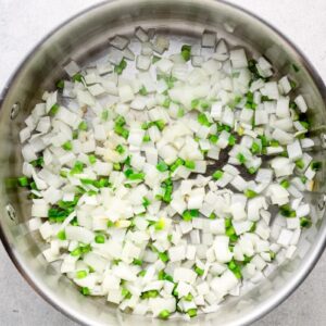sautéeing diced onion and jalapeno in a pan.