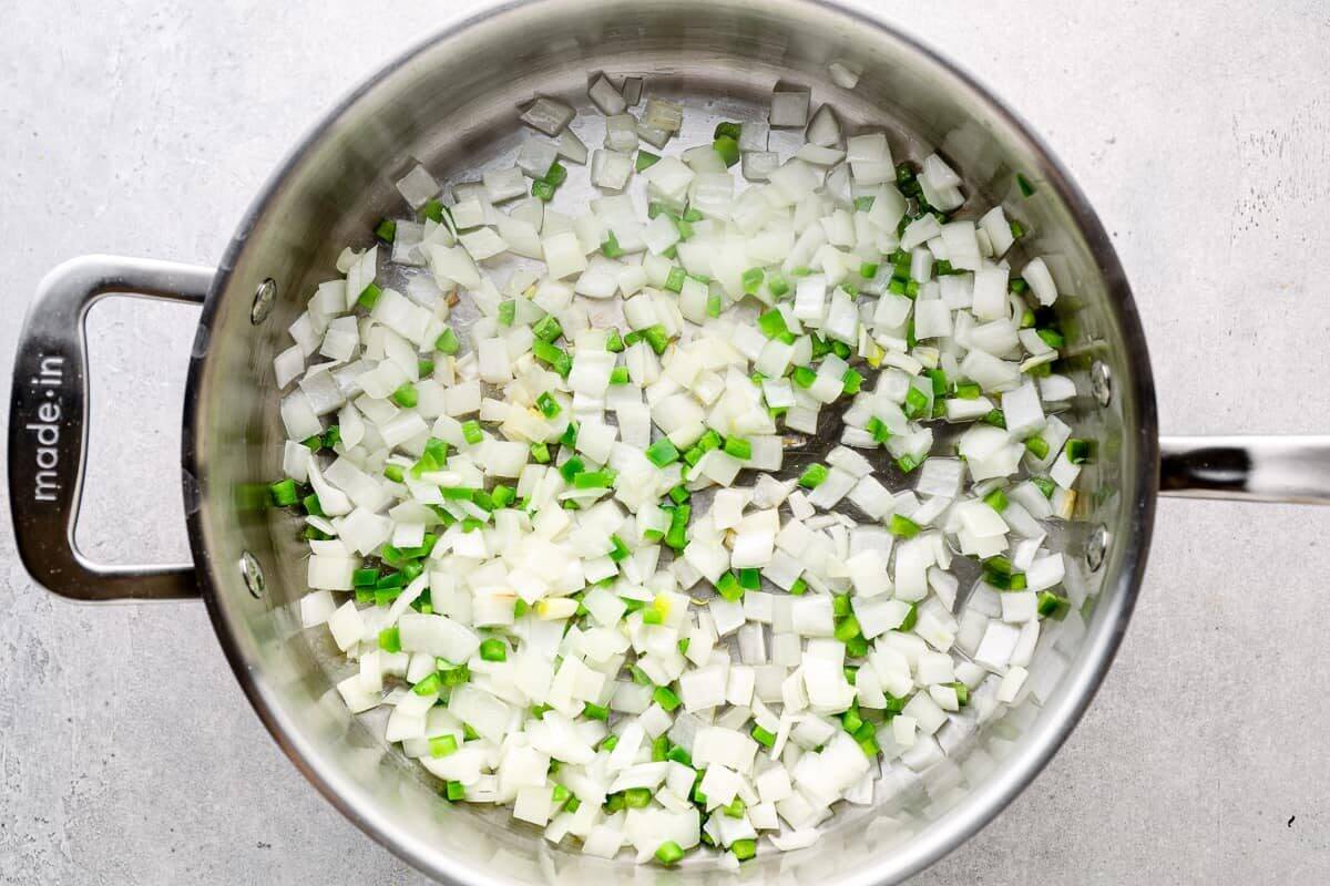 sautéeing diced onion and jalapeno in a pan.