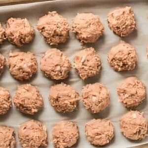 Ground chicken meatballs arranged on a baking sheet.