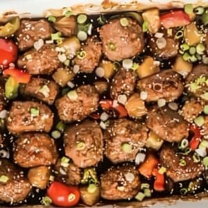 Baked Hawaiian chicken meatballs, garnished with sesame seeds and green onions.