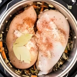 Raw chicken breasts added to an Instant Pot.