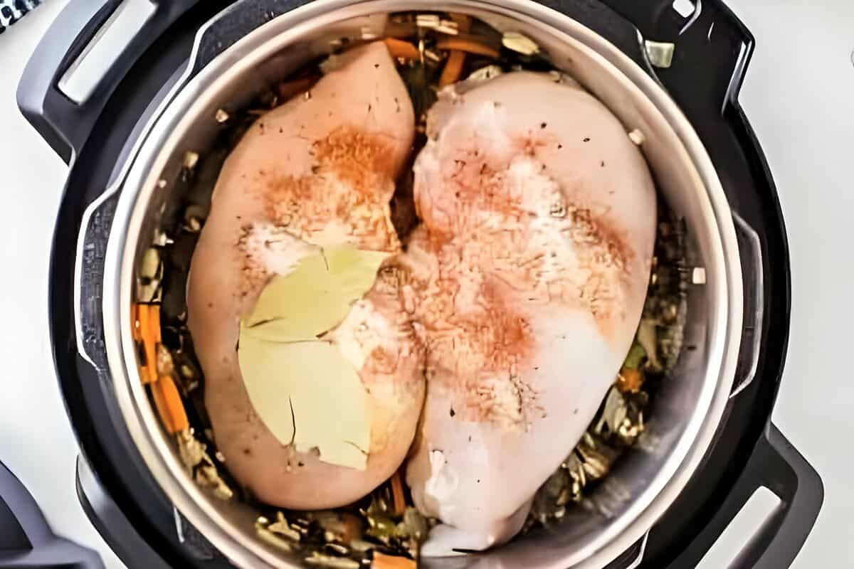 Raw chicken breasts added to an Instant Pot.