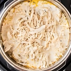 Shredded chicken added to an Instant Pot.