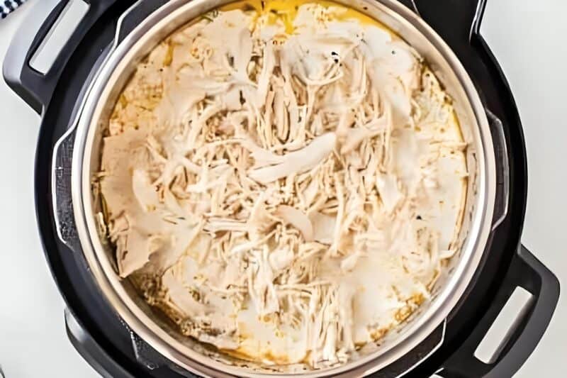 Shredded chicken added to an Instant Pot.