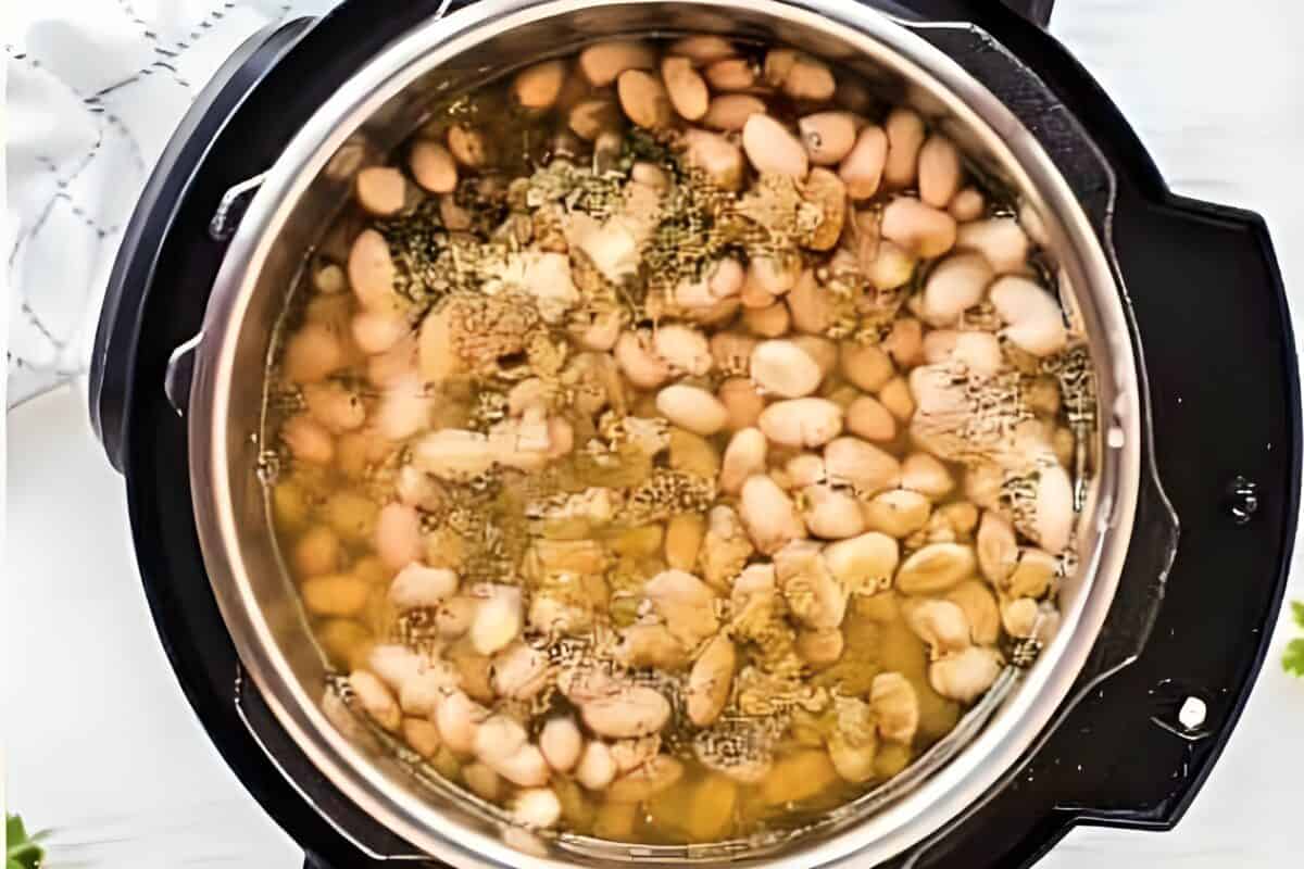 White beans, spices, and broth added to an Instant Pot.
