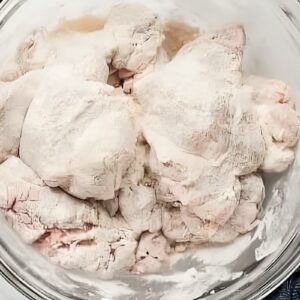 Chicken thighs coated in flour.