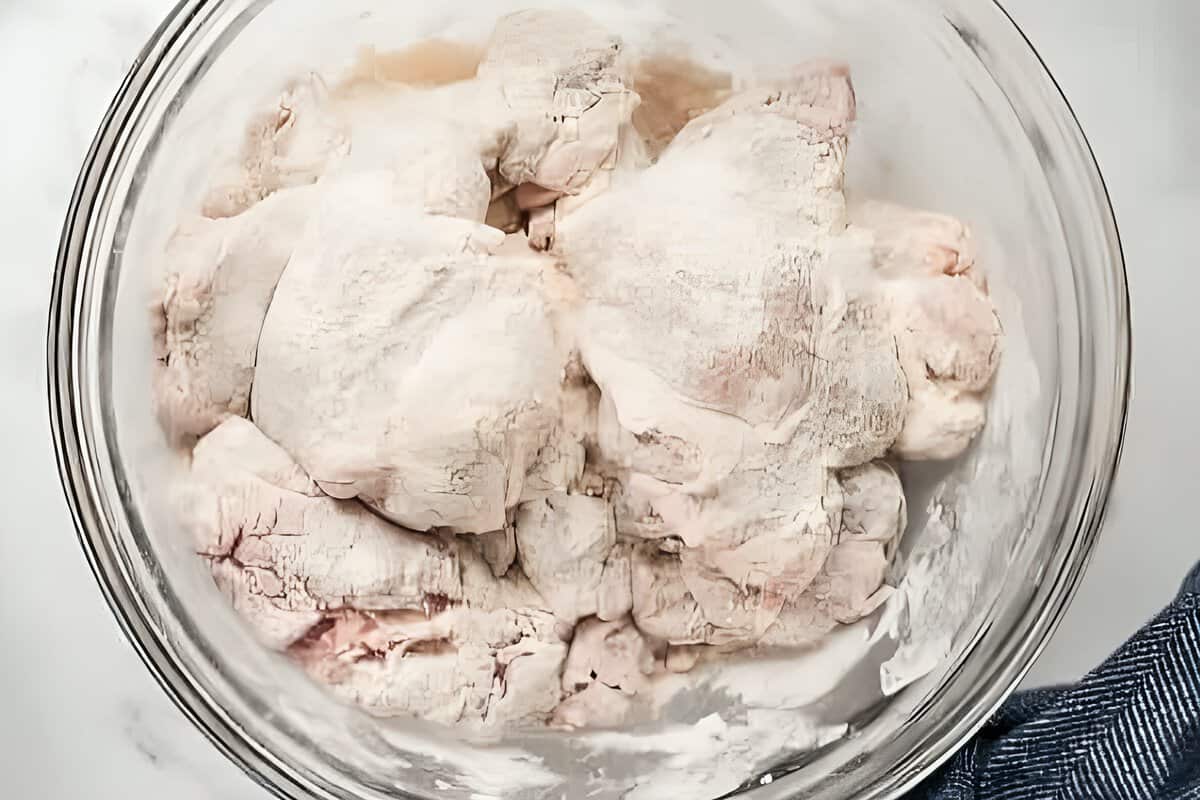 Chicken thighs coated in flour.