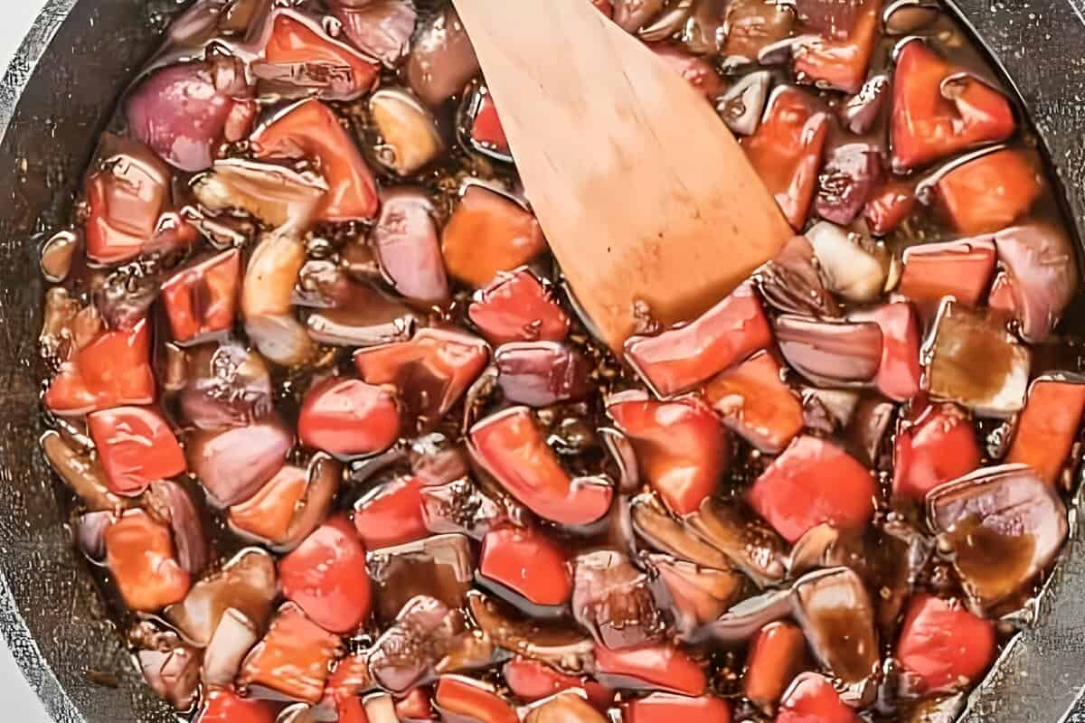 Peppers and onions cooking in a teriyaki sauce.