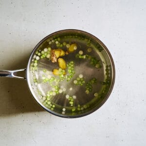 water with scallions, ginger, and salt in a saucepan.