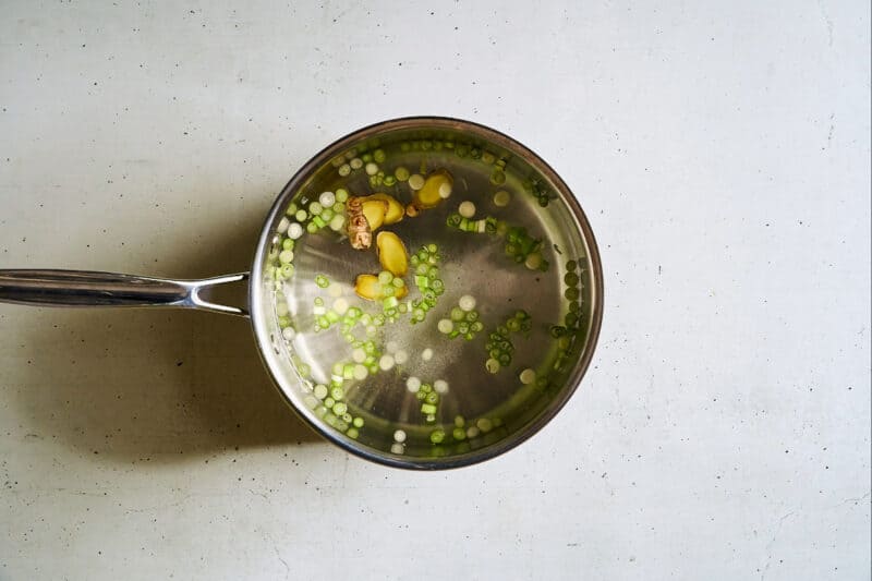 water with scallions, ginger, and salt in a saucepan.