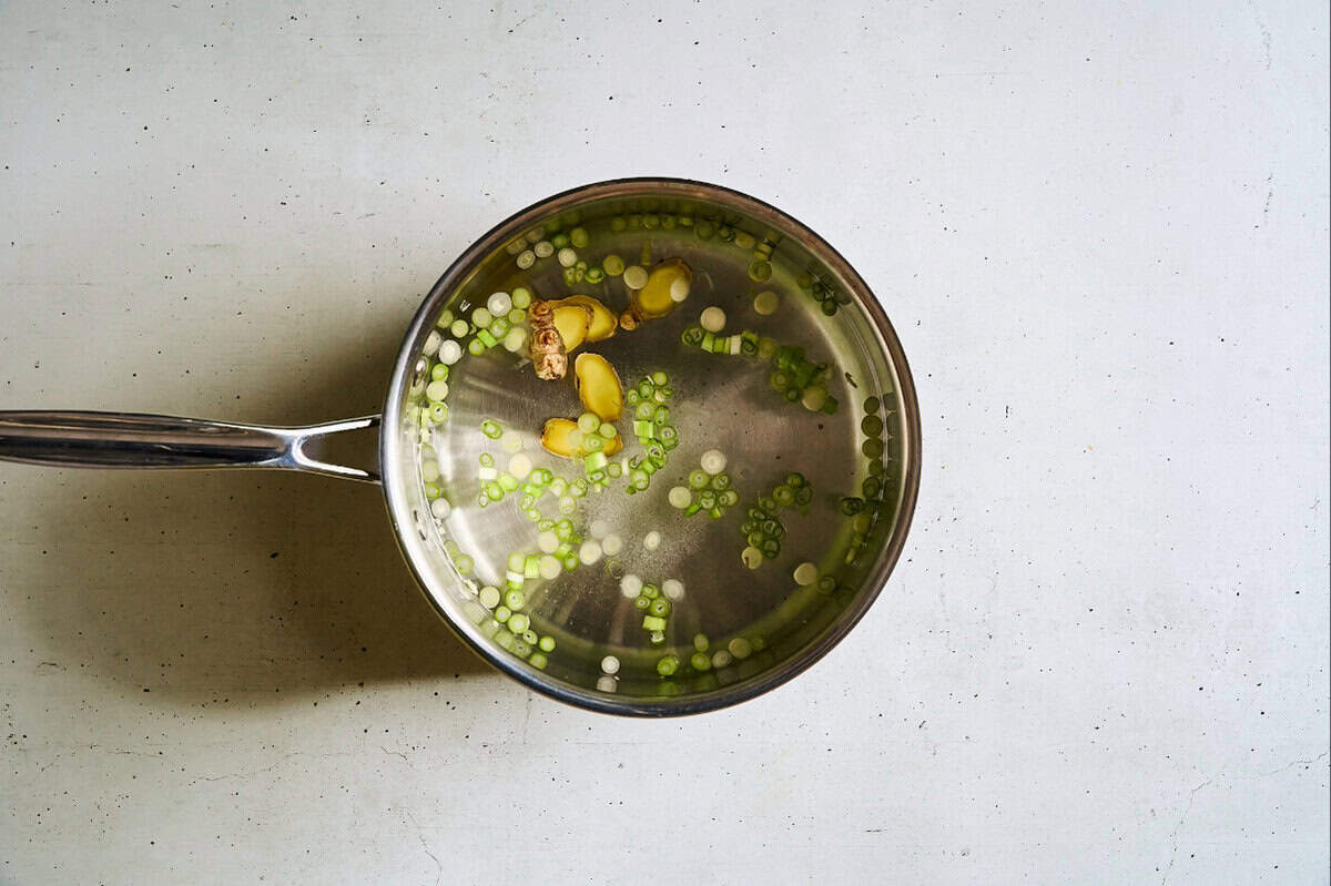 water with scallions, ginger, and salt in a saucepan.