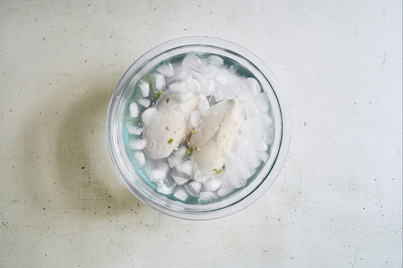 cooling poached chicken breasts in an ice bath.