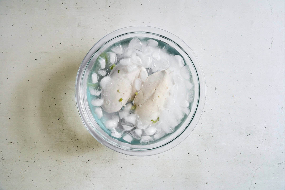 cooling poached chicken breasts in an ice bath.