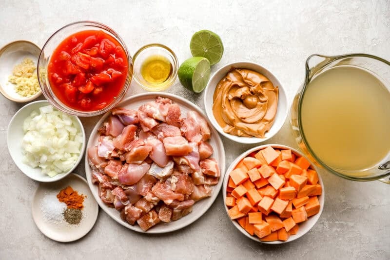 portioned ingredients for peanut chicken soup in individual containers.
