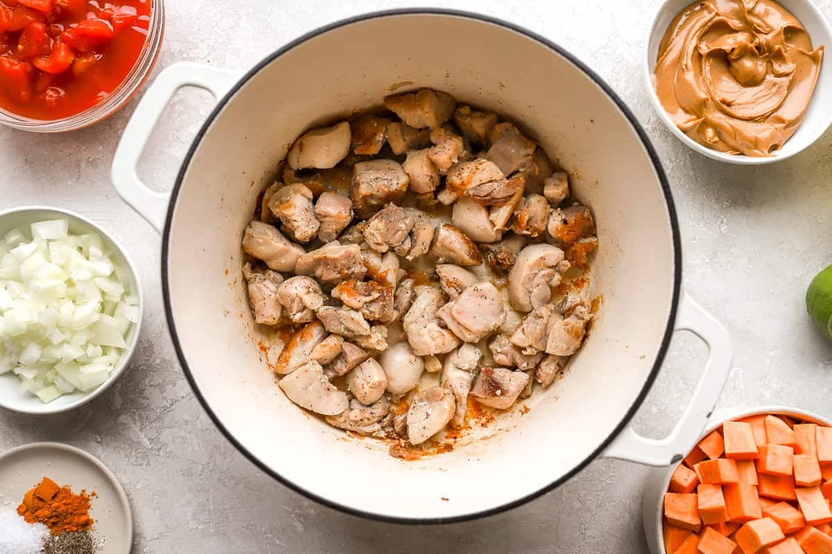 sautéeing diced chicken thighs in a dutch oven.