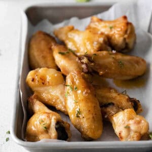 Hot honey chicken wings served in a rimmed baking sheet.