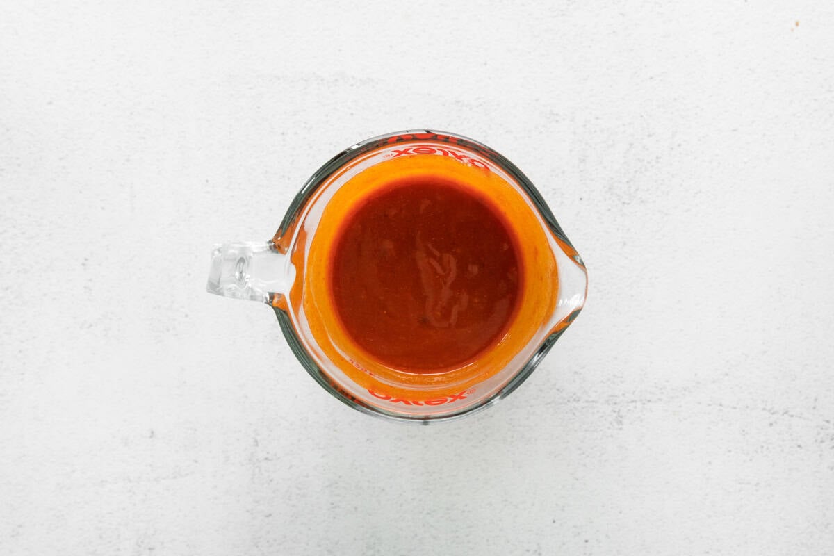 nashville hot sauce in a glass liquid measuring cup.