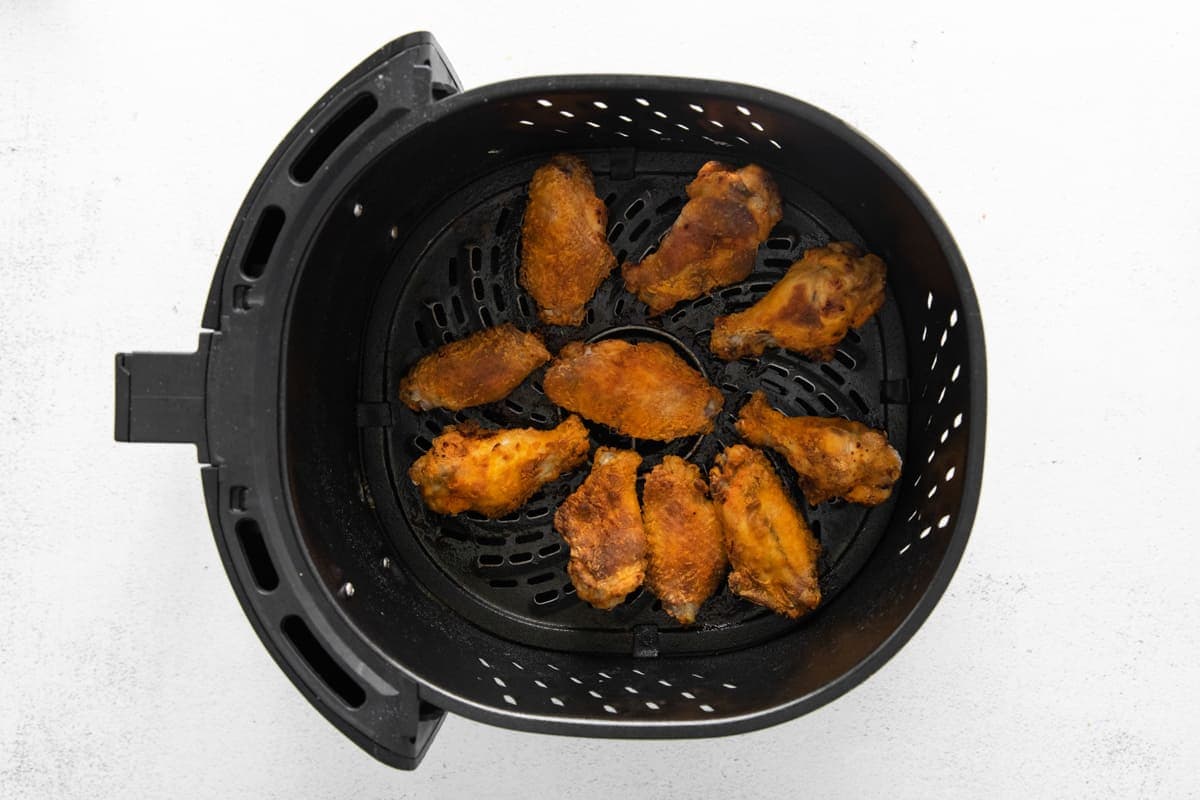air fried chicken wings in an air fryer basket.