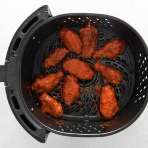 nashville hot chicken wings in an air fryer basket.