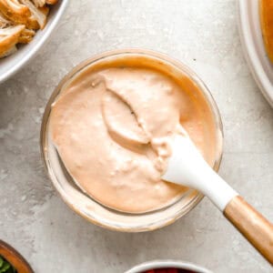 chipotle mayonnaise in a small glass bowl with a rubber spatula.