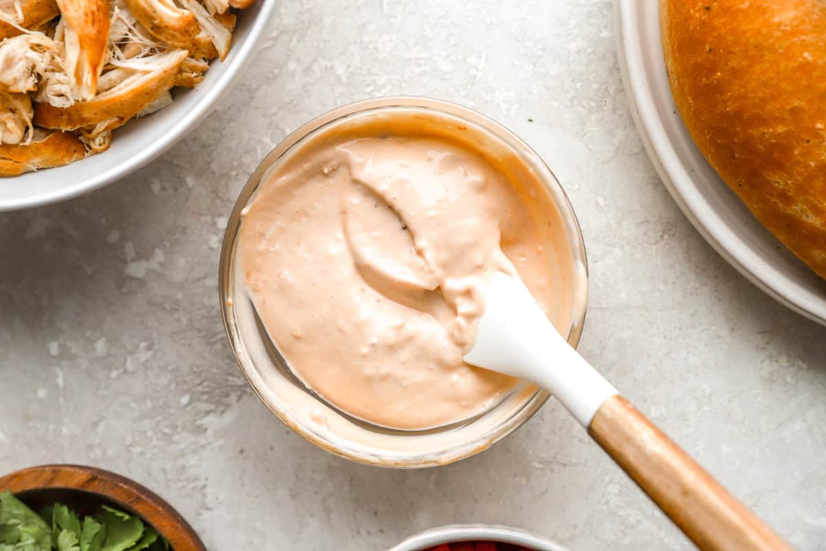 chipotle mayonnaise in a small glass bowl with a rubber spatula.