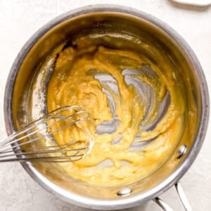 making a flour roux in a saucepan with a whisk.