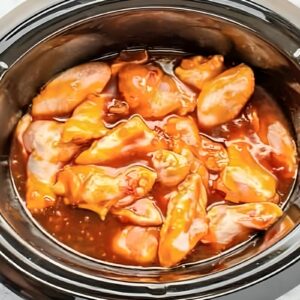 raw chicken wing portions and bourbon sauce in a crockpot.