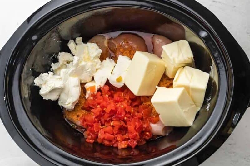 Queso chicken ingredients in a slow cooker.