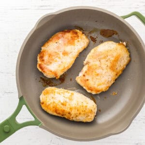 seared chicken breasts in a pan.