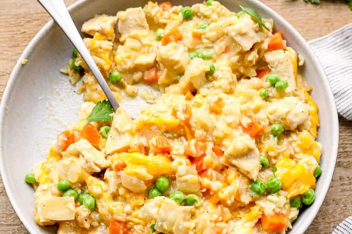 A serving of crockpot chicken and rice on a white plate with a fork.