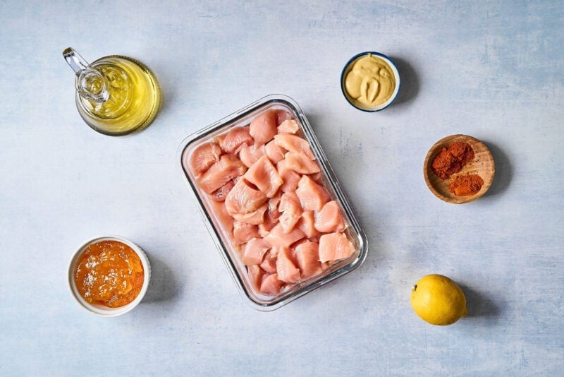 portioned ingredients for apricot chicken skewers in individual containers.
