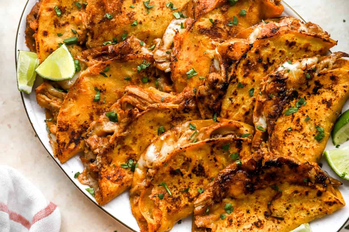 closeup of chicken birria tacos on an oval serving tray.