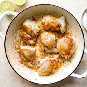 searing chicken thighs in a pan.
