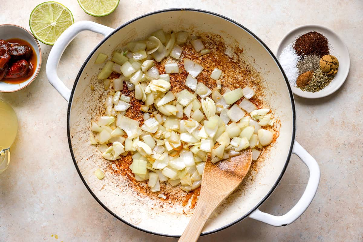 sautéeing onions in a pan with a wooden spoon.