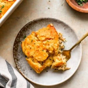 a serving of chicken cornbread casserole on a plate with a fork.