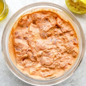 chicken thighs marinating in gyro seasoned yogurt.