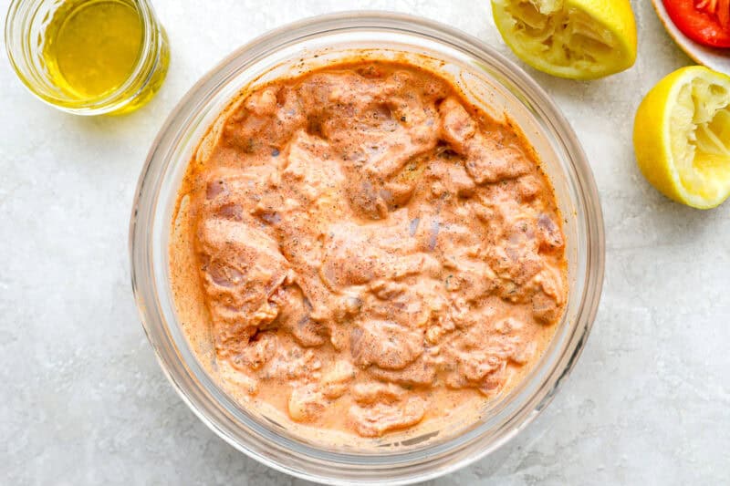 chicken thighs marinating in gyro seasoned yogurt.