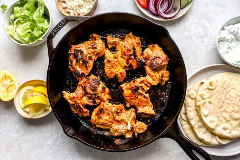 seared marinated chicken thighs in a cast iron pan.
