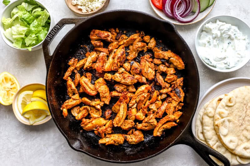 searing sliced chicken gyro meat in a cast iron skillet.