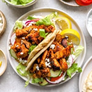 two chicken gyro pita wraps on a plate.
